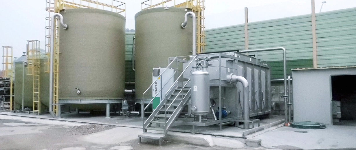 A dissolved air flotation unit onsite next to a pair of silos.