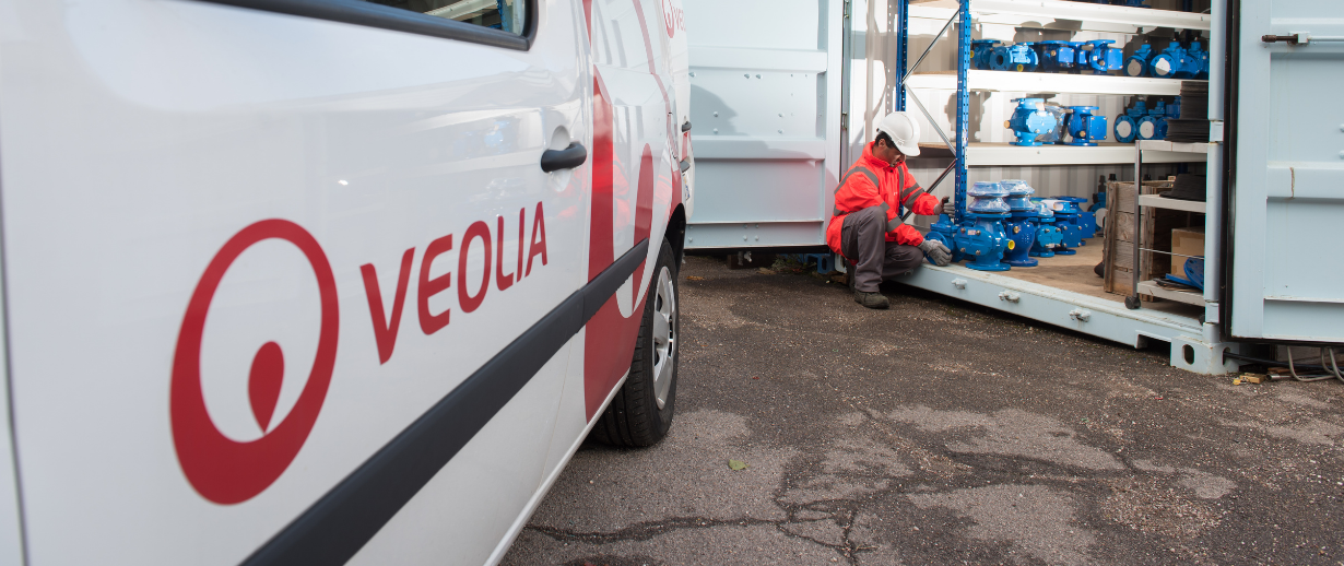 A Veolia branded van with an engineer in PPE picking up a pump next to it.